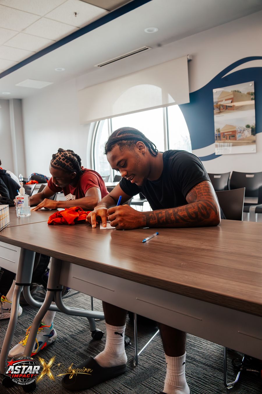 A coach working with an athlete at the financial literacy session